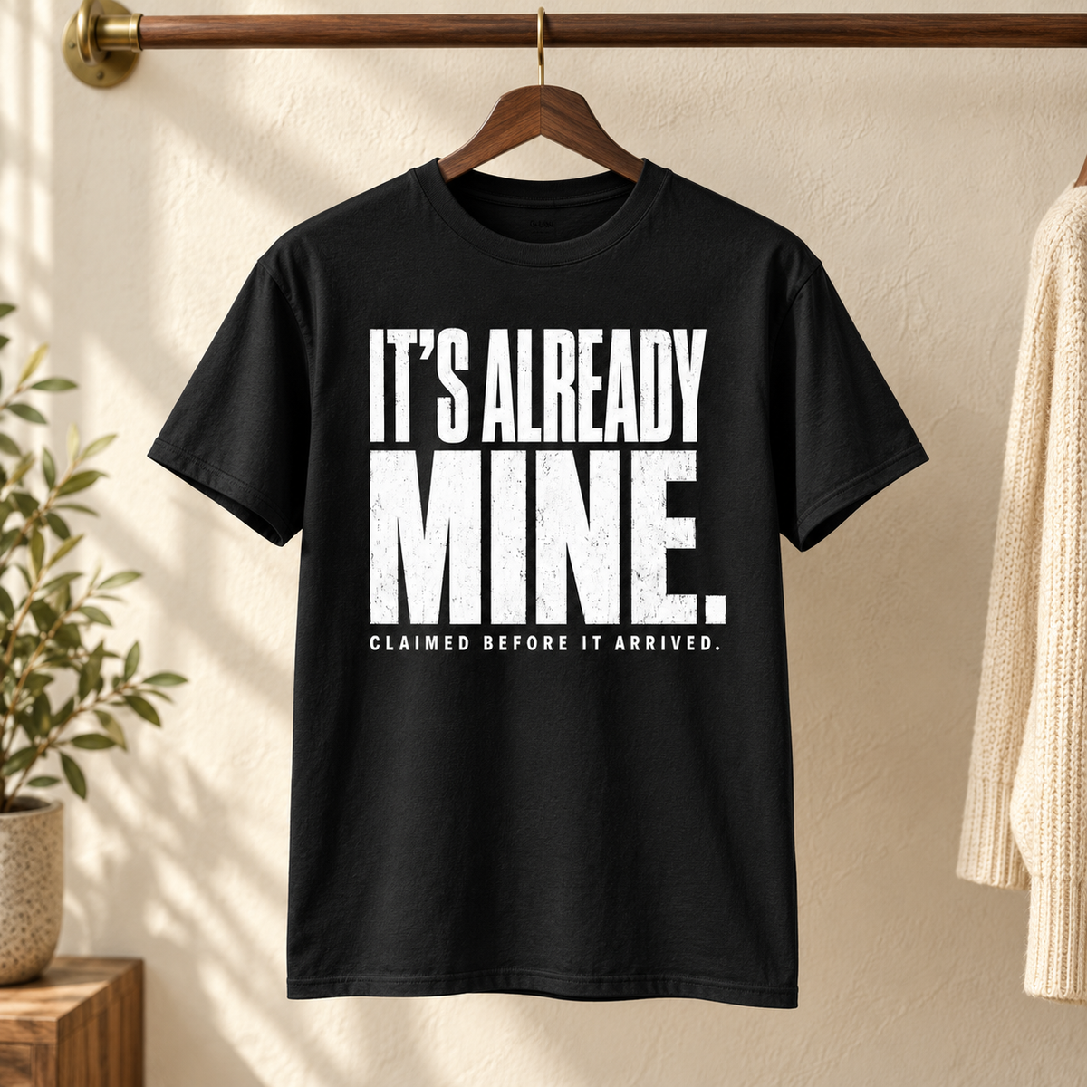 Black It's Already Mine tee hanging in a boutique
